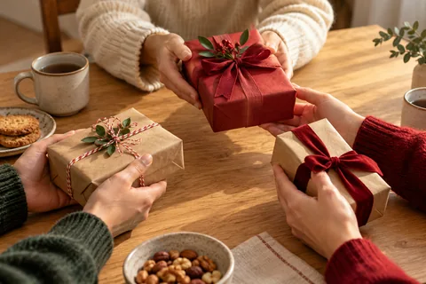 Manos intercambiando pequeños regalos envueltos